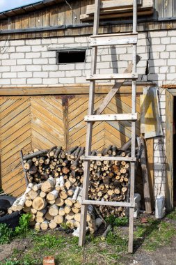 Yakacak odun yığınının yanındaki tahta merdiven..