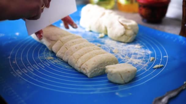 A női kezek tésztát dagasztanak a kék asztalra. Desszertet főzni otthon a sütőben. — Stock videók