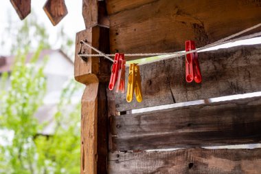 Plastik mandallar eski bir ahşap arka planda bir ipe tutunuyorlar..