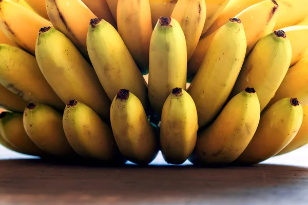 Ramo de plátanos maduros de fondo. Frutas frescas en la mesa. — Foto de Stock