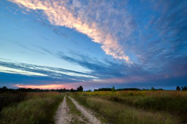 Yaz günbatımında yol ile dramatik bir gökyüzü. Güzel bulutlar.