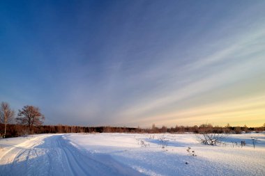 Karla kaplı bir yol ya da güneşli bir kış gününde kayak.