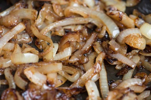 Tavada caramelizing soğan