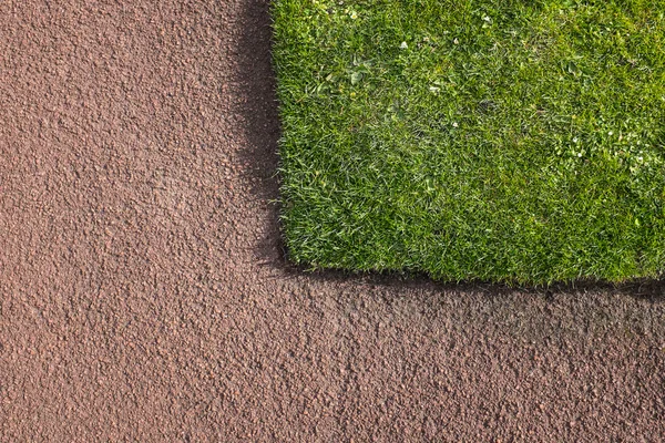 Yeşil çim kırmızı tarmacadam yoluna bitişik köşesinde