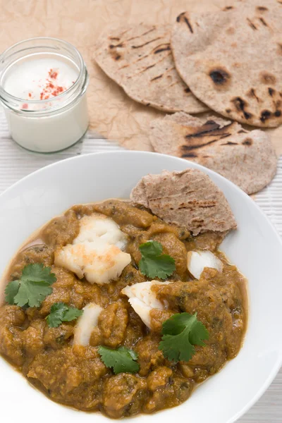 Fish curry meal with chapati flatbread and raita