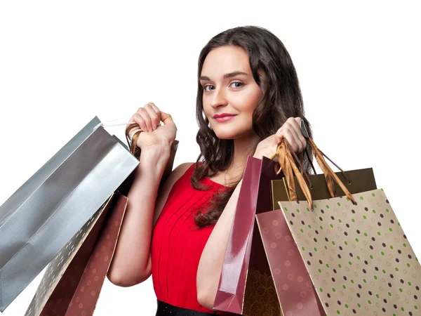 Lachende vrouw in rode jurk met shopping tassen — Stockfoto