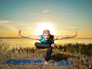 Yoga yaparak gülümseyen adam açık havada egzersiz
