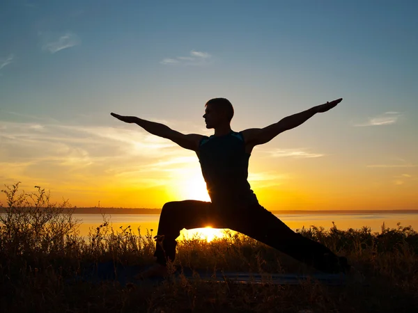 Man in yoga warrior pose standing  outdoors — Stock Photo, Image