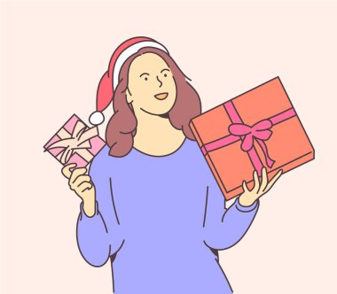 Christmas or New year concept. Young happy woman dressed in santa hat keeps boxes with christmas gifts.	