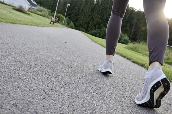 Closeup of a woman in running shoes, walking or taking a run to be fit and active
