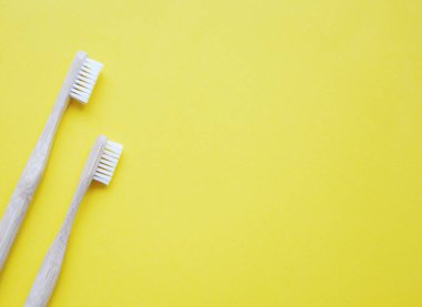 Sarı arka planda iki diş fırçası resmi.