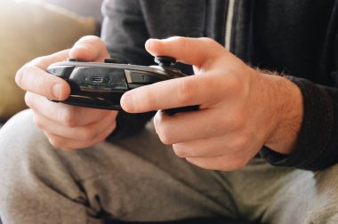 Bilgisayar oyunu oynayan ve kumandalı bir adamın yakın plan görüntüsü.