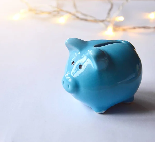 Photo of a blue piggy bank and lights on white background