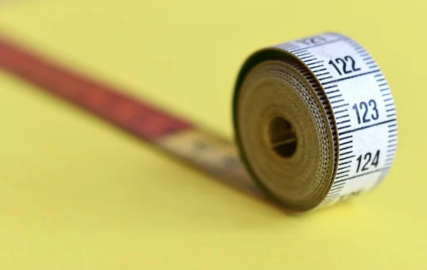黄色の背景に測定テープのクローズマクロ — ストック写真