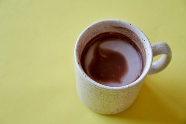 Sarı arka planda bir fincan sıcak çikolata.