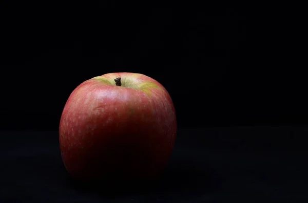 Photo of a red apple on black background