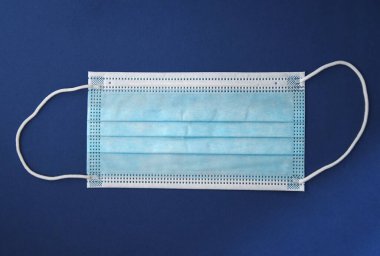 Koyu mavi arka planda mavi bir maskenin resmi.