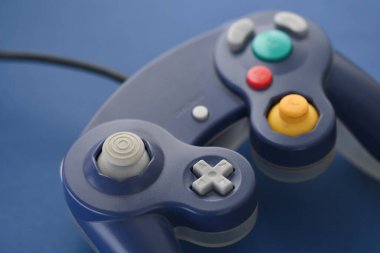 Mavi arkaplandaki bir oyun denetleyicisinin fotoğrafı