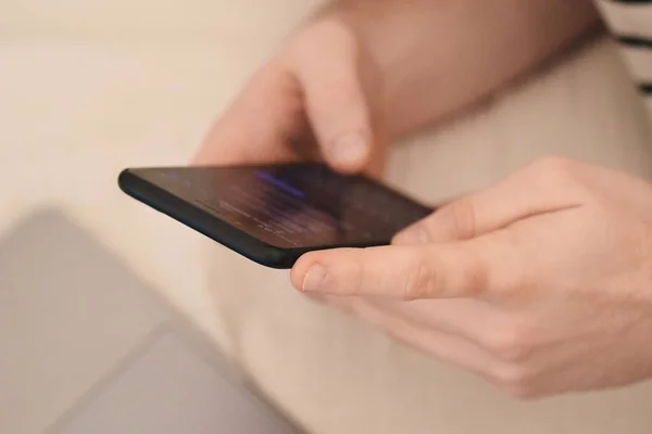 Telefonunu ve bilgisayarını aynı anda kullanan bir adam.