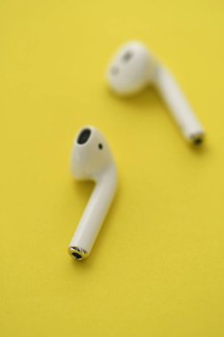 Sarı arkaplanda kablosuz akıllı kulaklıkların fotoğrafı