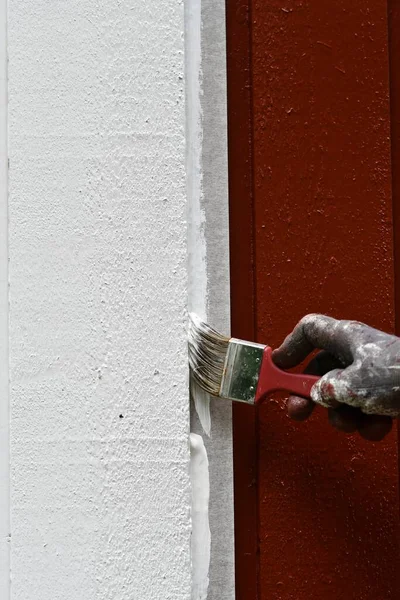 A man painting his house with white color, home improvement
