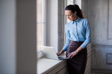 Genç başarılı mutlu gülümseyen iş kadın üstünde laptop