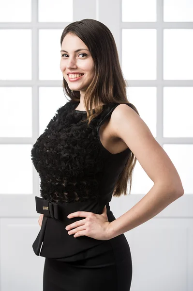 Hermosa mujer de pie en un vestido negro sobre el estudio loft casa puertas interiores detrás de — Foto de Stock