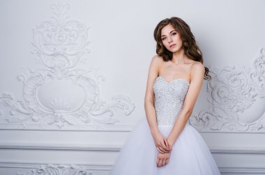 Gelinlik iç, poz uzun kıvırcık saçlı güzel gülümseyen gelin kadın. Güzellik kapalı portre.