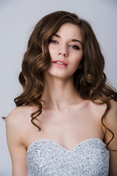 Retrato cercano de la hermosa novia sonriente mujer con el pelo rizado largo posando en vestido de novia en el interior y sonriendo. Retrato interior de belleza . — Foto de Stock