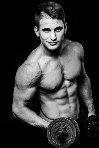 Scuro colpo di contrasto in bianco e nero del braccio dello stomaco giovane uomo fitness muscolare. Allenamento con manubri isolati — Foto Stock