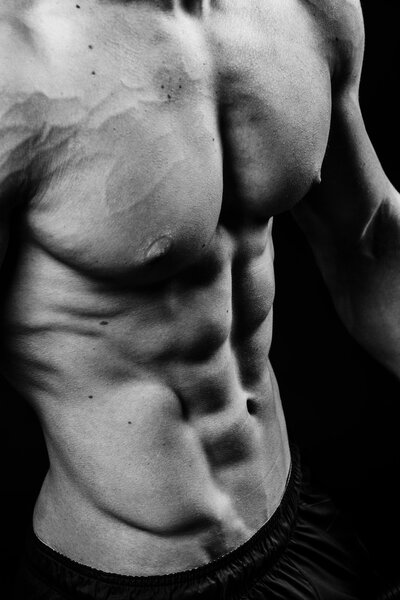 Closeup of cool perfect sexy strong sensual bare torso with abs pectorals 6 pack muscles chest black and white studio, vertical picture