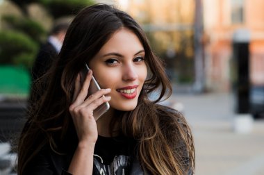 Kadın telefonu konuşuyor. Cityscape açık sokak arka plan İş Merkezi yakınındaki üzerinde smartphone üzerinde konuşmak Closeup genç mutlu güzel gülümseyen kız Bayan. Pozitif yüz ifade insan duygu