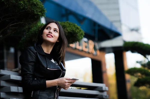 Femme souriante envoyant des sms dans la rue — Photo