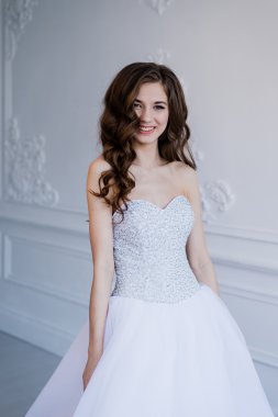 Güzel gülümseyen gelin kadın portresi gelinlik iç, poz ve gülümseyen uzun kıvırcık saçlı kapatın. Güzellik kapalı portre.