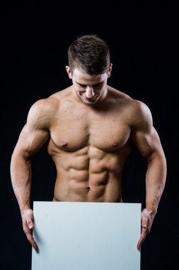 Full isolated studio picture from a young naked man with white sign board.