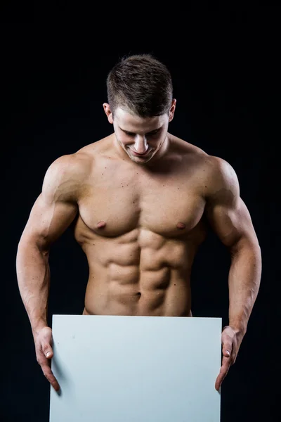 Full isolated studio picture from a young naked man with white sign board. — Zdjęcie stockowe