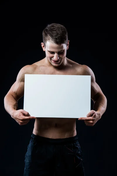 Full isolated studio picture from a young naked man with white sign board. — Φωτογραφία Αρχείου