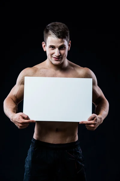 Full isolated studio picture from a young naked man with white sign board. — Stock Photo, Image