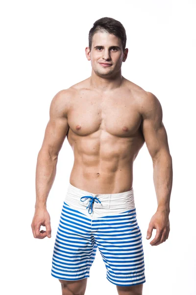 Портрет красивого молодого мускулистого мужчины в купальниках с сложенными на белом фоне руками — стоковое фото