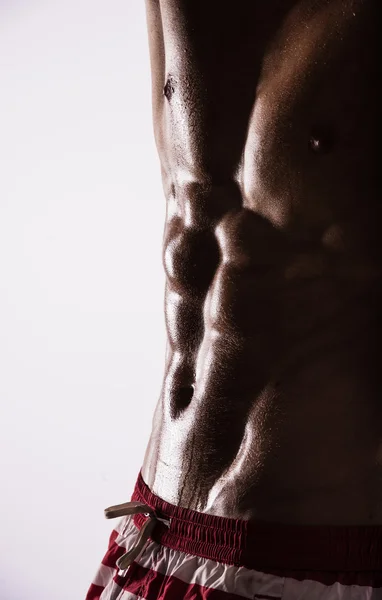 Vue de côté silhouette de jeune sportif musclé sexy torse nu homme chaud posant montrant corps de sport humide avec abdominaux pectoraux cool muscle forte poitrine biceps studio sur blanc. Perles sueur entraînement gymnase . — Photo