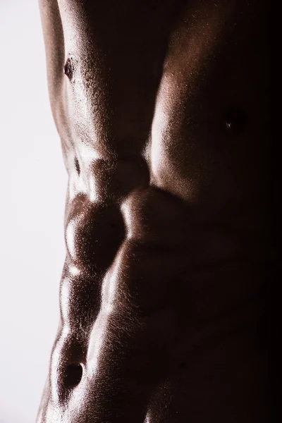 Vue de côté silhouette de jeune sportif musclé sexy torse nu homme chaud posant montrant corps de sport humide avec abdominaux pectoraux cool muscle forte poitrine biceps studio sur blanc. Perles sueur entraînement gymnase . — Photo