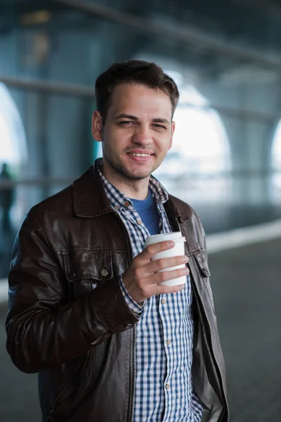 Retrato al aire libre del joven moderno con café para llevar taza, sonriendo — Foto de Stock