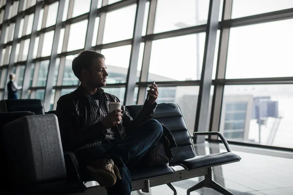 Ο άνθρωπος που περιμένει στο αεροδρόμιο lounge γραπτών μηνυμάτων με το έξυπνο τηλέφωνο — Φωτογραφία Αρχείου