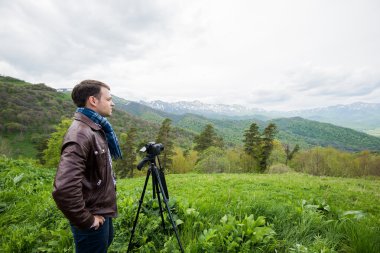 Profesyonel fotoğrafçı kaya tepe üzerinde kamera ile fotoğraf çeker