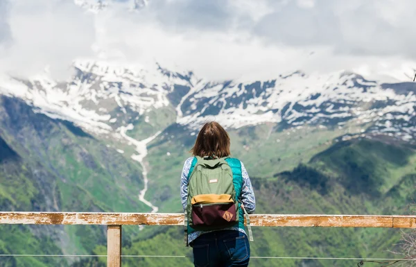 Ung kvinna är stående på viewpoint och ser vackra bergslandskap. Vandring kvinnlig turist med ryggsäck avslappnande på toppen njuta av spektakulär utsikt. — Stockfoto