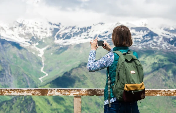 Kvinnan hiker ta foto med smartphone på berg. Backpacker foton liggande på mobiltelefonen. — Stockfoto