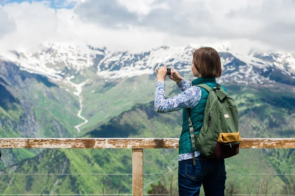 Närbild bild av ung kvinnlig turist med smartphone ta foto och njuter av bergsutsikt. — Stockfoto