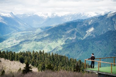 Man tourist admiring views of the mountains clipart