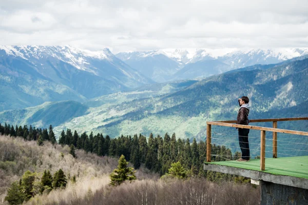 Avslappnad man observerar majestätiska berg med en hand över hans ögon — Stockfoto