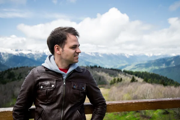 Portrait of a young smiling wanderer man traveler enjoying his recreation time in nature